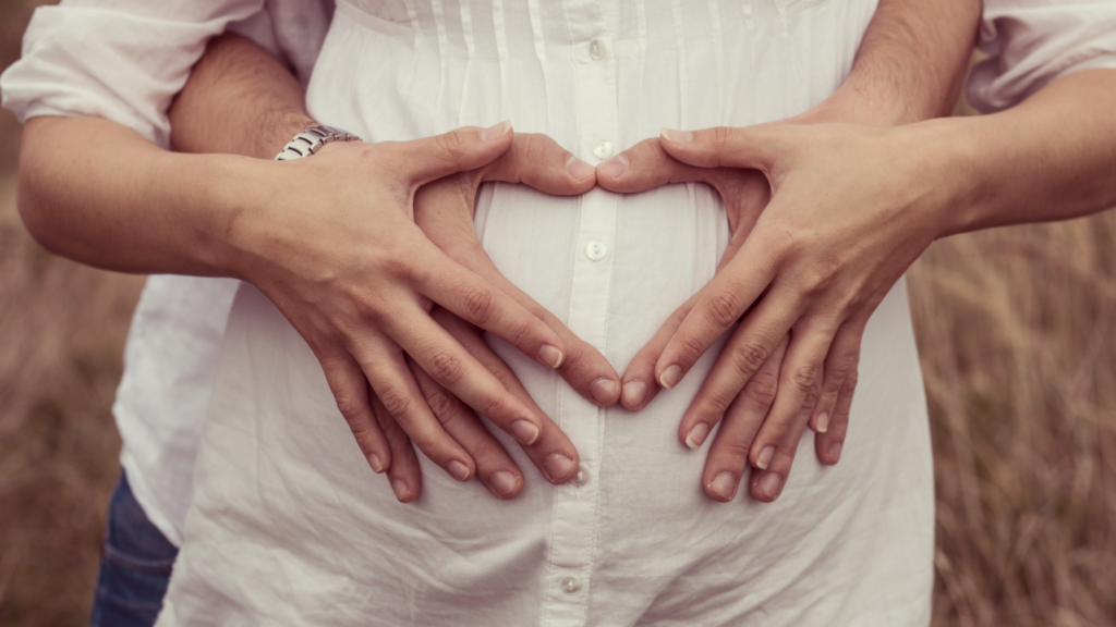 Casal com as mãos na barriga da mulher grávida